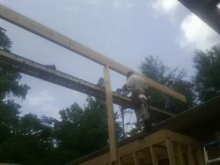 Carpenter setting a ridge beam over a new addition frame — Ice Dam Removal by Roofing Brothers in Mertztown