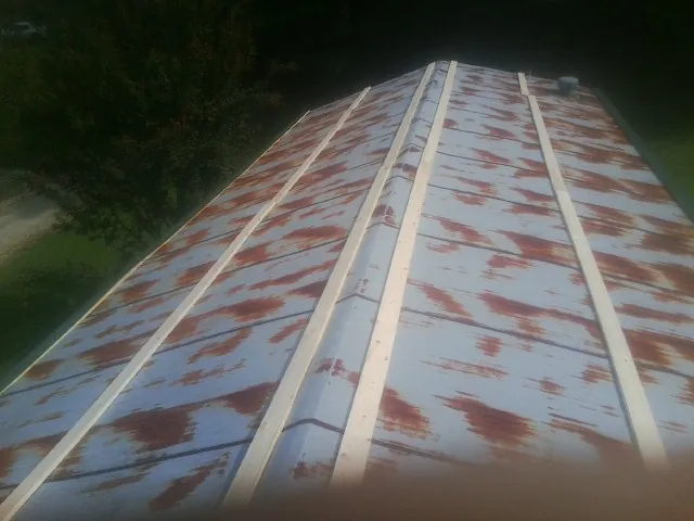 Rusted metal roof panels with new wood purlins before replacement — Storm Damage Roof Repair in Mertztown by Roofing Brothers