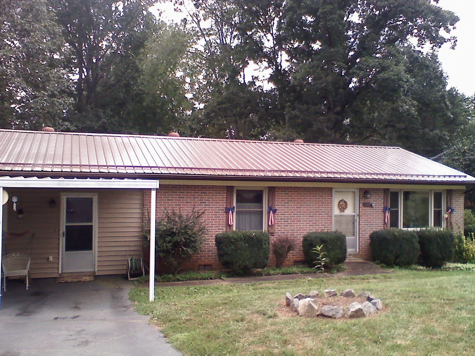 Bronze metal roof and carport on a brick ranch home — Roof Repair work by our crew in Mertztown